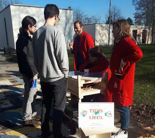 Étudiants autour d’un mobilier en bois, en extérieur