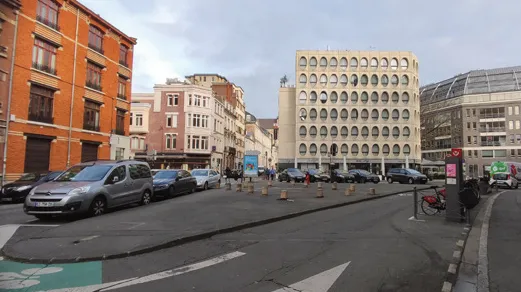 Carrefour lillois bordé d’immeubles, avec une large chaussée
