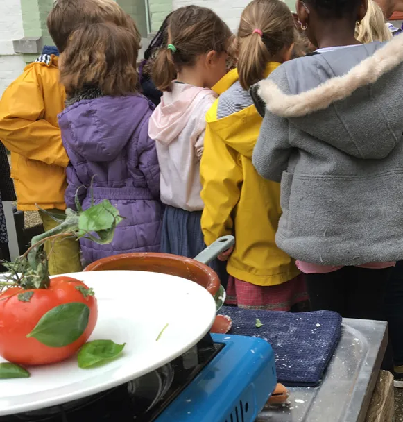 Enfants en ciré devant une assiette de tomates