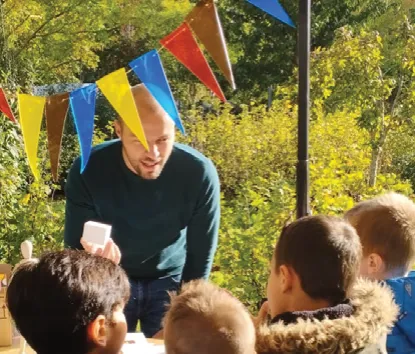 Animateur échangeant avec des enfants sous les fanions