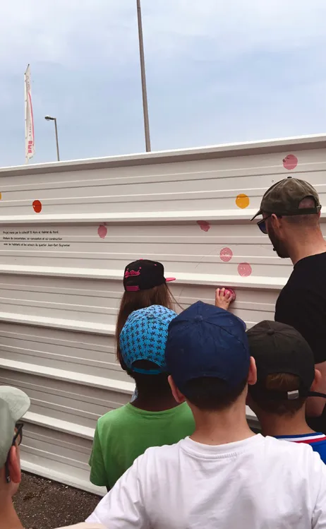 Enfants découvrant les premiers motifs peints sur le mur